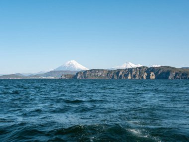 Pasifik Okyanusu 'nun Avacha Körfezi' ne giden bir yattan inin. Yelkenli yattan limana, volkanlara, sonbahar tepelerine, mavi gökyüzüne kadar manzarayı. Kamçatka Yarımadası, Rusya.