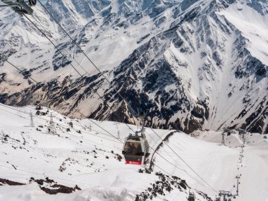 Cheget 'ten Kafkas Dağları manzarası, 3050 metre yükseklik, Kabardino-Balkaria, Rusya. Kar kaplı dağların arka planında insanlar olan kayak kaldırma kabini.