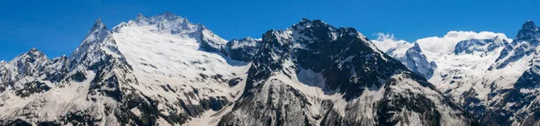 从Mussa Achitara山到高加索山脉的全景 美丽的高山 白雪覆盖 尖尖的山峰映衬着蓝天 Dombai Karachay Cherkess Republic Russia — 图库照片