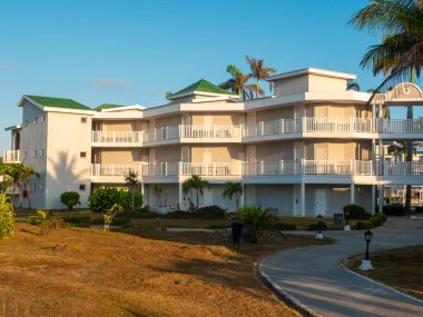 Cayo Coco, Küba, 16 Mayıs 2021: Tryp Cayo Coco otelinin bölgesi sabah erken saatlerde. Otel evleri mavi gökyüzü, yüksek palmiyeler ve yeşil bitkilerle çevrili..