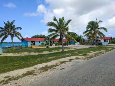 Cayo Guillermo, Küba, 16 Mayıs 2021: Deniz kıyısında kırmızı kiremit çatılı parlak yol kenarı dükkanı. Binanın etrafında yeşil çalılar ve uzun palmiyeler yetişiyor..