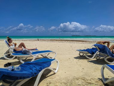 Cayo Guillermo, Küba, 16 Mayıs 2021 Pilar Beach 'te insanlar rahatlar, güneşlenir ve yüzer. Kadınlar mavi güneş altında uzanır havlularla ve gök mavisi okyanusa hayran kalırlar..