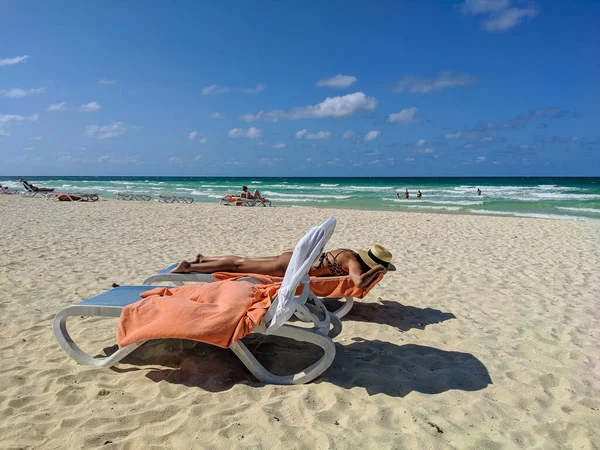 2021年5月16日 古巴卡约科科 人们在古巴库班海滩放松 晒日光浴和游泳 戴帽子的女人躺在一条用毛巾围成的蓝色脉轮上 欣赏蔚蓝的大海 — 图库照片