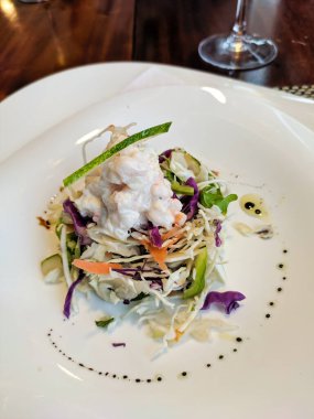 Karides sebze salatası bir restoranda beyaz bir tabakta servis edilir. Yakın plan. Dikey.