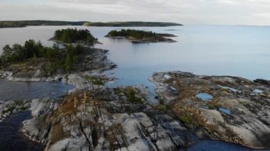 Kayalık sahili ve doğal havuzu olan hava manzaralı bir ada. Rus Karelia. Ladoga.