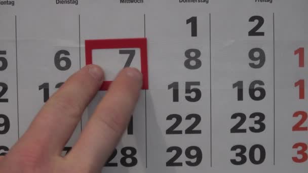 Hombre dedos de la mano mueve calendario marco rojo ventana En el siguiente día negro — Vídeo de stock