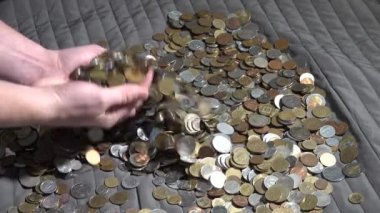 İnsan elleri farklı ülkelerden bir sürü madeni parayı karıştırır. Ses