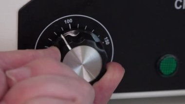 Ellerin fırının ısısını açıp kapatıyor. Kuru ısıda. ayar düğmesi.