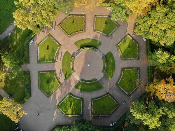 Landscape design castle palace. Garden park, an area with a flat lawn and flowers. round rhombus square square with walking paths. Autumn. Aerial view from top down.