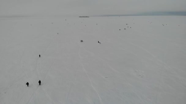 渔夫们在冬天带着帐篷在冰上钓鱼.高层建筑物的背景 — 图库视频影像