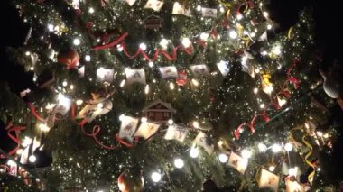 Sokak lambalarıyla süslenmiş büyük bir Noel ağacı. Bayraklar oyuncaklar ve ampuller
