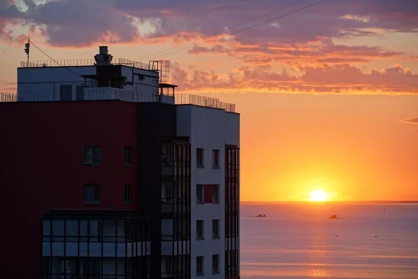 Una ciudad al amanecer al atardecer. casa de edificio residencial de varios pisos. mar de agua océano —  Fotos de Stock