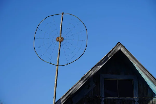 Stara antena analogowa z okrągłym drutem. Domowej roboty. na starym drewnianym budynku wsi — Zdjęcie stockowe