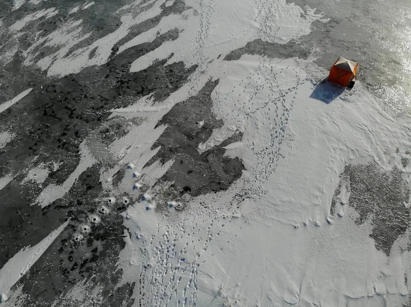 Pesca de Inverno. tenda solitária no gelo. pegadas na neve. Buracos. vista aérea. — Fotografia de Stock