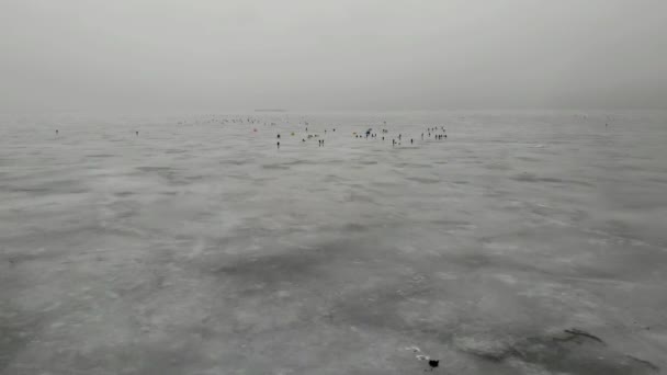 氷釣りだ。人々のグループ多くの漁師の薄い氷。冬と灰色の空. — ストック動画