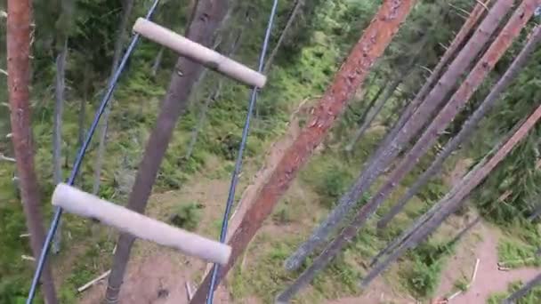 Touwladder in het touwenpark. Uitzicht vanaf de eerste persoon. hoge boomhoogte extreme sport — Stockvideo