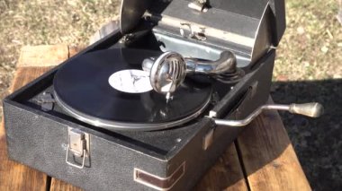 Eski büyük siyah gramofon dış mekanda. Vinil plak dönüyor. Kapat.