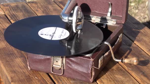 Old small brown gramophone phonograph outdoor. vinyl record spinning. close up — Stock Video