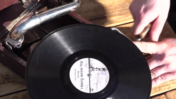 Die Hand des Mannes schaltet das Grammophon ein, um Schallplattenmusik abzuspielen. Nahaufnahme — Stockvideo