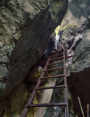 Şelalenin üzerinde paslı demir bir merdiven.