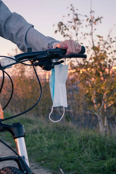 With a medical mask on a bicycle in the middle of a pandemic