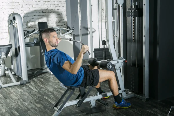 Jovem no ginásio exercitando-se com a máquina lat pulldown — Fotografia de Stock