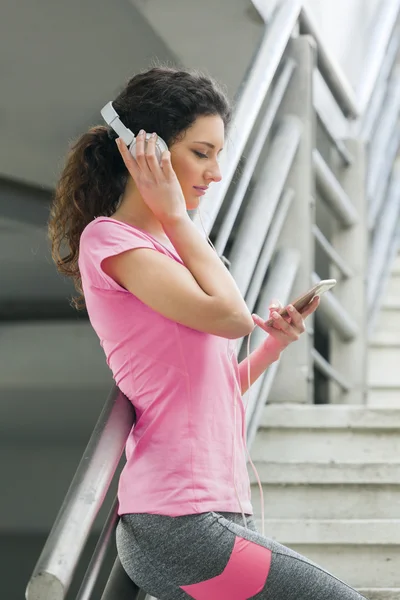 Fitness meisje luisteren naar muziek tussen de trainingen — Stockfoto