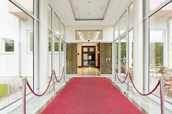 Elegante entrada de hotel de luxo com tapete vermelho — Fotografia de Stock