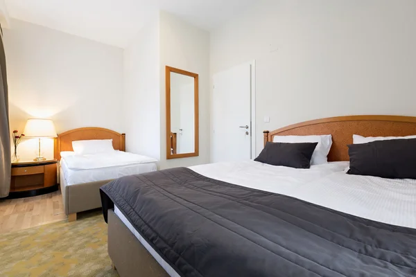 Interior of a hotel bedroom with a double bed and single bed — Stock Photo, Image