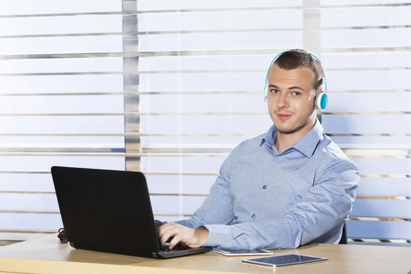 Jonge man bezig met computer en luisteren naar muziek — Stockfoto