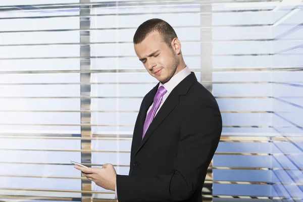 Young businessman confused by text message — Stock Photo, Image