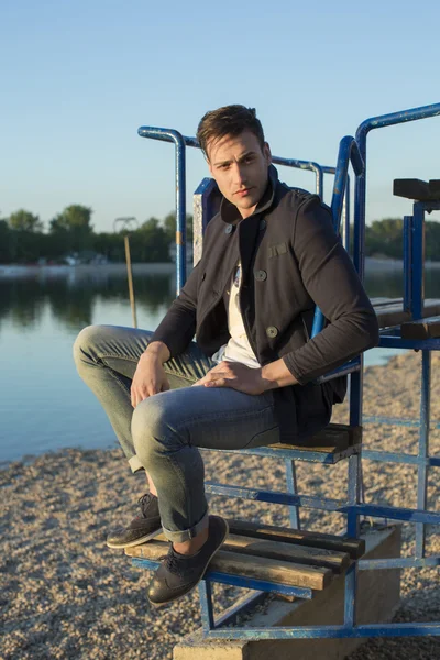 Bello uomo in spiaggia al tramonto — Foto Stock