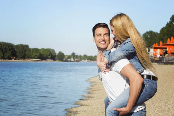 Young couple having fun at the beach on a sunny day — Stock Photo, Image