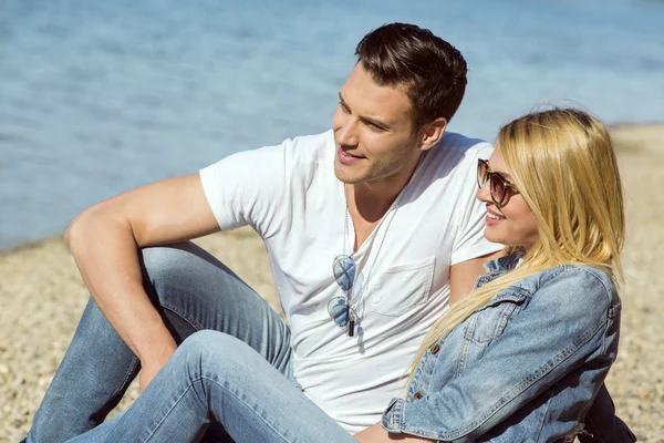 Ungt par på stranden en solig dag — Stockfoto