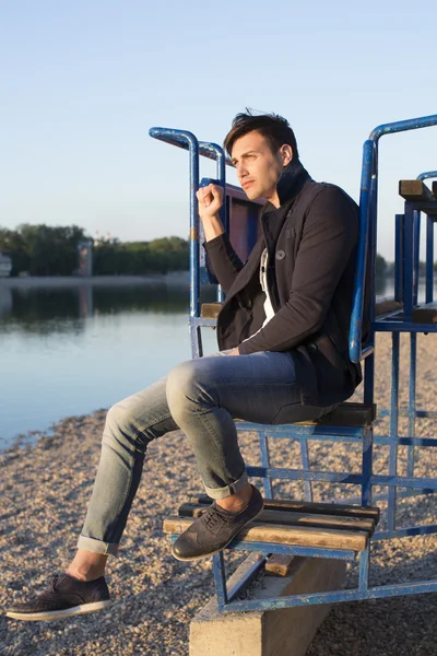 Handsome man at the beach at sunset — Stock Photo, Image