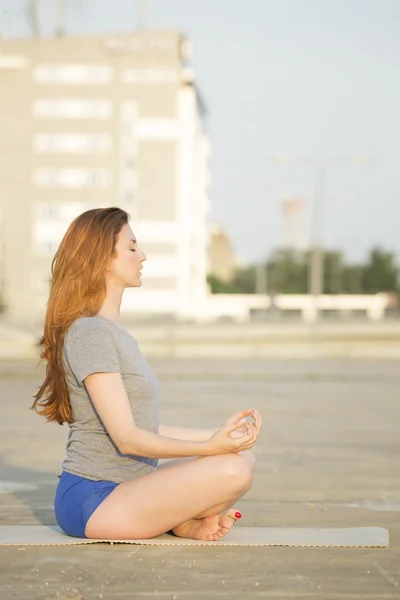 Красивая женщина медитирует на открытом воздухе в городе — стоковое фото