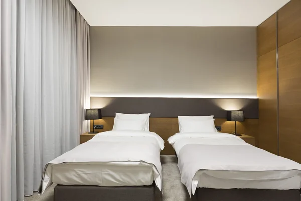 Interior of a new modern hotel bedroom in the evening — Stock Photo, Image