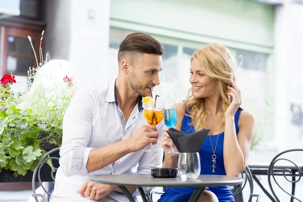 Beautiful couple at the bar drinking cocktails