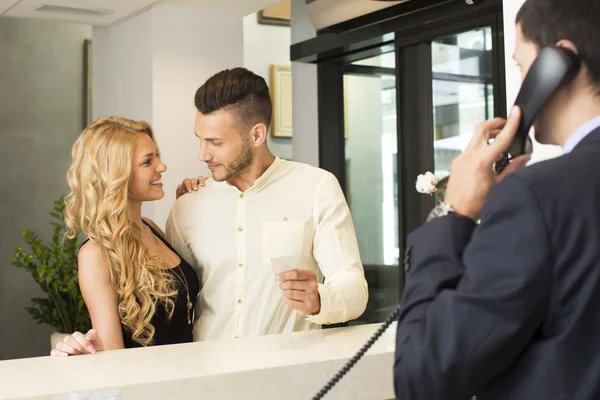 Jovem casal na recepção do hotel — Fotografia de Stock