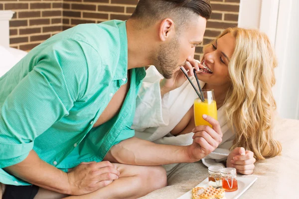 Glada lekfulla par med frukost i sängen — Stockfoto