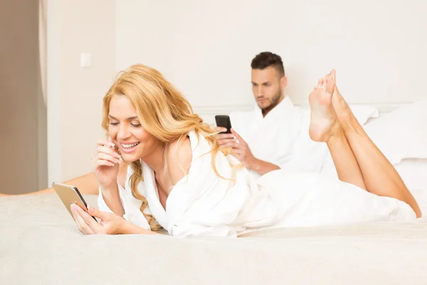 Couple au lit, en utilisant des smartphones — Photo