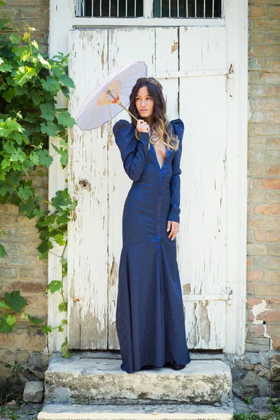 Hermosa mujer en vestido azul con una sombrilla — Foto de Stock