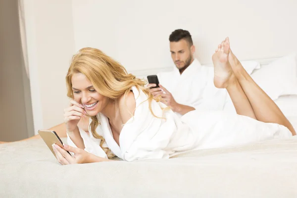 Couple au lit, en utilisant des smartphones — Photo
