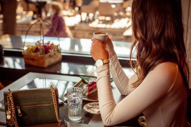 Muhteşem genç bayan restoranda tek başına kahve içiyor.