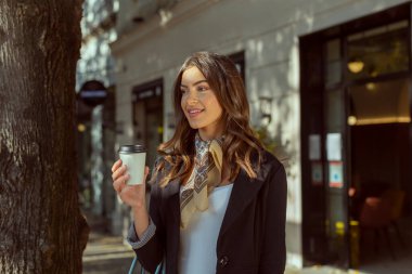  Sokakta yürüyen bir fincan kahveyle güzel bir kadın.