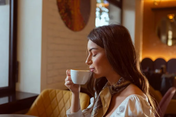 目を閉じてコーヒーを楽しむ美しい若い女性 — ストック写真