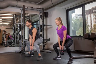 Modern spor salonunda birlikte çalışan yakışıklı çift.