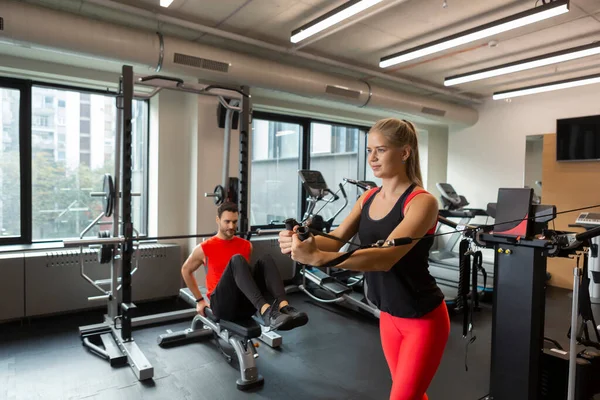 Modern spor salonunda birlikte çalışan yakışıklı çift.