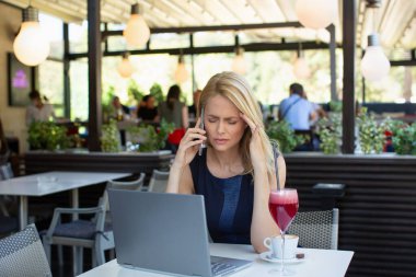 Gözleri kapali bir kadin akilli telefondan konusurken basi agriyor