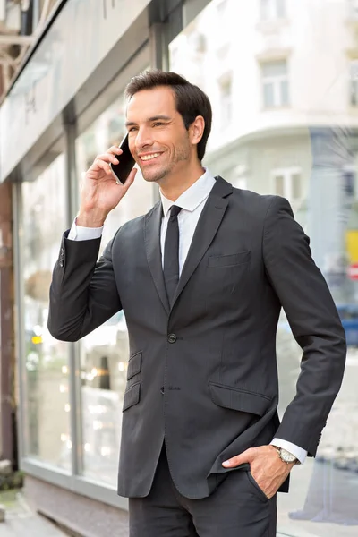 スーツ姿のビジネスマンが屋外の携帯電話で話してる — ストック写真